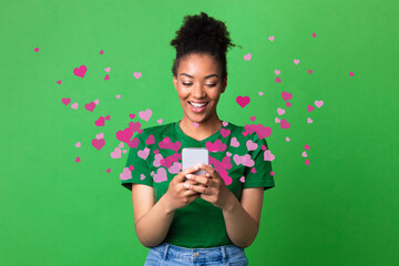 Black woman sending love message on smartphone, hearts flying away