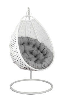 Rattan wicker garden swing chair with a pillow isolated on white.