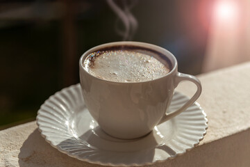 A cup of cappuccino in sunlight