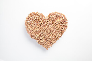 heart made of raw lentils on white background, healthy life and nutrition concept
