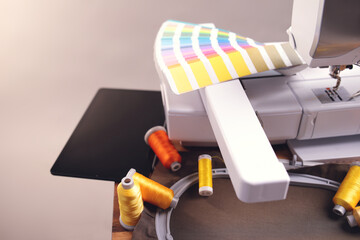 Still life of color selection process for an embroidery project positioned on a wooden table with...