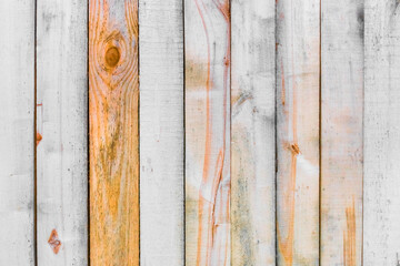 Old white fence boards with orange paint on the surface of vertical lines wooden texture background