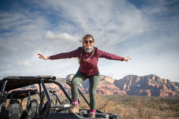 A young woman on top of an all terrain vehicle in a beautiful landscape 