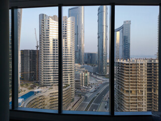 Top aerial view shot of city skyscrapers from a modern office space | Al Reem island Sun and Sky towers and landmarks in Abu Dhabi, UAE