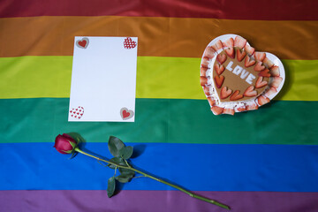 Strawberry and cream cake with natural rose and photo frame on the flag of gay pride for Valentine´s day.