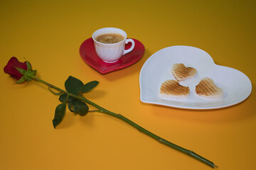 Coffee with toast and natural rose on a yellow background for breakfast on Valentine´s day.
