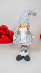 Close up of cute doll with gift boxes in form of heart on isolated white background. Concept of holidays, presents and good mood.