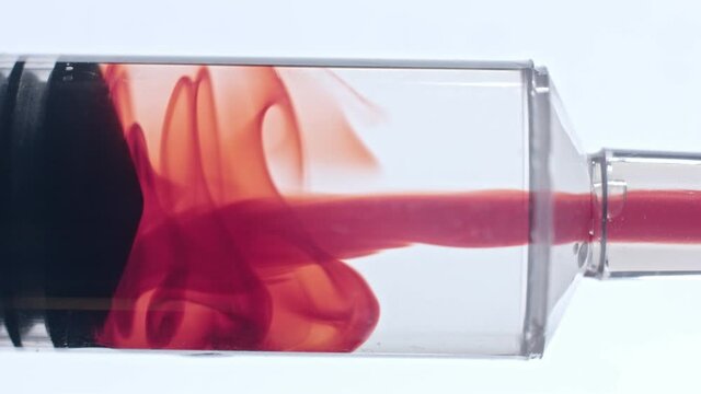 Red blood sucked into syringe tube closeup macro of vaccine testing process