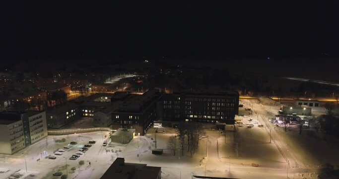 Aerial view of hospital at night. Winter city landscape. Snowy streets with cars at night.