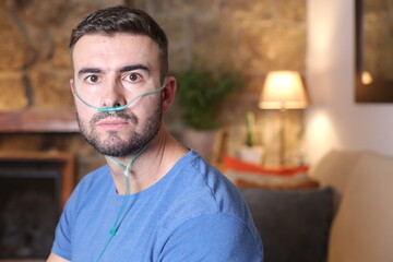 Man receiving oxygen through nasal tube  - obrazy, fototapety, plakaty