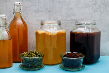 Glass jars with kombucha fermented on ground coffee beans and lemon verbena leaves tea beverage. Alternative medicine.