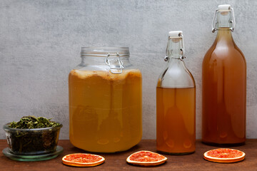 Glass jars with kombucha fermented on ground coffee beans and lemon verbena leaves tea beverage. Alternative medicine.