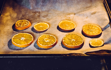 Drying fresh orange slices on oven pan. Making arts and crafts supplies. Dry slices cooking.