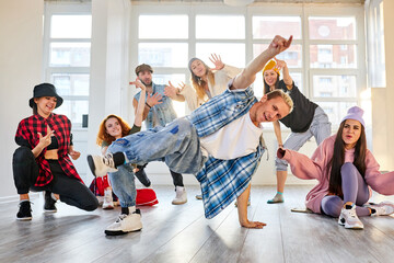young people repeating a performance, hip-hop and break dance in studio, talented youth, man in stylish clothes show his abilities