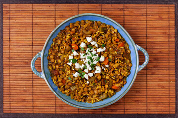 Green lentil soup dish flat lay. Lentil soup with rice, carrot and celery in a plate.