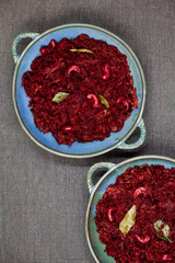 Beetroot curry made from grated beetroot with coconut milk, grated coconut and cashews. Indian cuisine meal in plate placed on black slate. Top view.