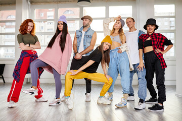 youth having fun in choreography class, posing with female trainer in studio, hip-hop dancers