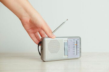A hand on an old radio on a white background. Radio concept. Vintage style.