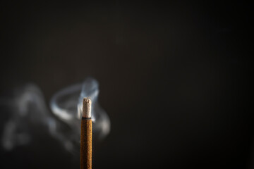 Asian incense stick burning with smoke, close up, macro