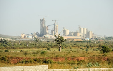 Fototapeta na wymiar cement factory next to a baobab forest