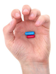 Hand with red and blue capsule.