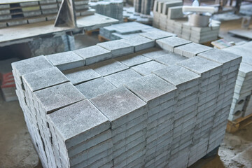 Paving slabs factory. Tiles piled in pallets.