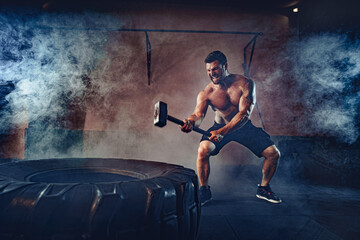 Sports training for endurance, man hits hammer. Concept workout.