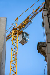 Fototapeta na wymiar Yellow colored heavy tower crane working between the buildings in Istanbul Istiklal Street.