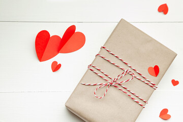 Valentines day gift box and red paper hearts on white background