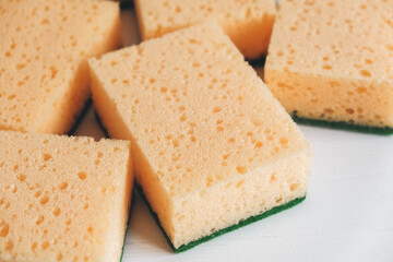 Yellow porous sponges on a white background. Top view. Copy, empty space for text