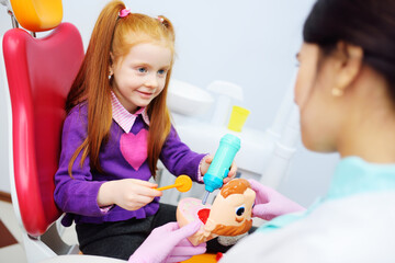 The dentist tells the child about oral hygiene