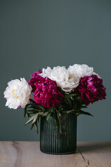 A bouquet of colorful peonies in a vase.