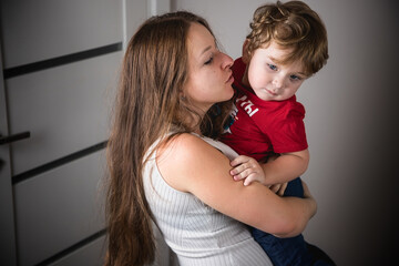 A woman with her son in her arms. Happy family. Real emotions.