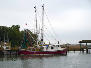 Commercial shrimp boat dock at a riverside marina.
