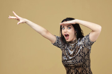charming brunette pulls her hand and looks in amazement at the camera