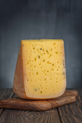 Piece of ammergauer beer cheese on a light wooden table