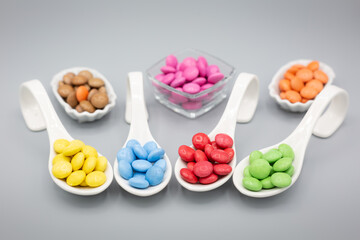 trybowls with smarties in different colors on grey background for birthday or party