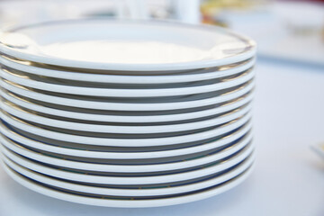A stack of white plates on a light background. Life style