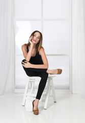 Fototapeta na wymiar Fashion pose - woman sits on chair in model pose in high heels