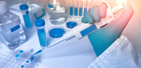Hand in glove with automatic pipette and samples, panoramic image. Polymerase Chain Reaction PCR...