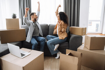 Overjoyed married multiracial couple buy new apartment, feeling euphoric. Happy caucasian man and...