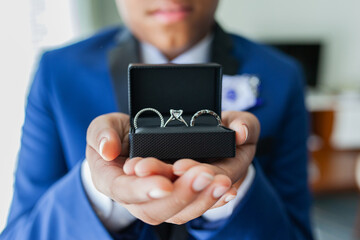 young man holding wedding rings