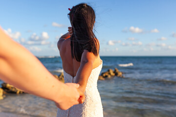 Fototapeta na wymiar bride holding hand of the groom on the beach