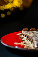 chocolate pancake with bananas, nuts and chocolate sauce. the toning. selective focus. a rolled chocolate pancake is a calorie bomb