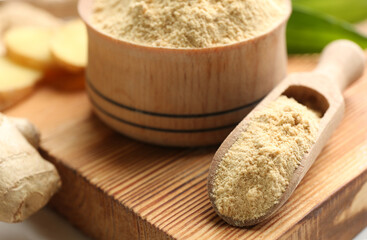 Dry powdered ginger on wooden board, closeup