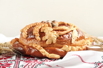 Rushnyk with korovai on light background, closeup. Ukrainian bread and salt welcoming tradition