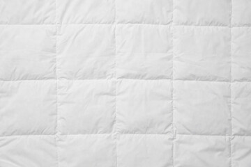 Soft quilted blanket as background, top view