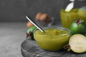 Feijoa jam on grey table, closeup. Space for text