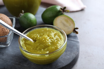 Feijoa jam in glass bowl on grey table, closeup
