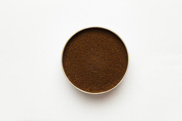 ground coffee in a round cup on a former background